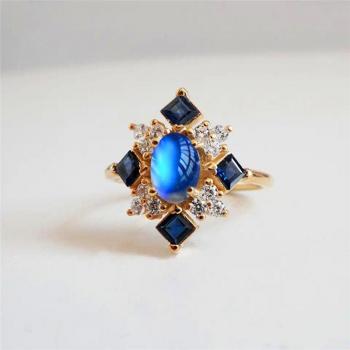 Anillo de lujo dorado con piedra lunar y cristal cuadrado azul