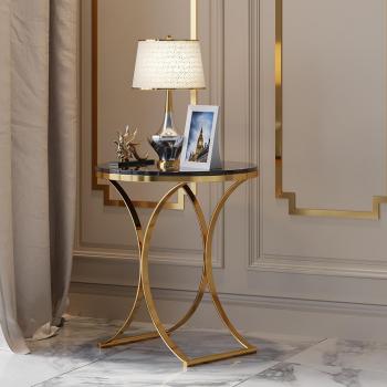 Stilvoller runder Tisch aus schwarzem Stein mit goldener X-Basis