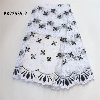 Tissu lumineux aux dentelles blanches et motifs africains